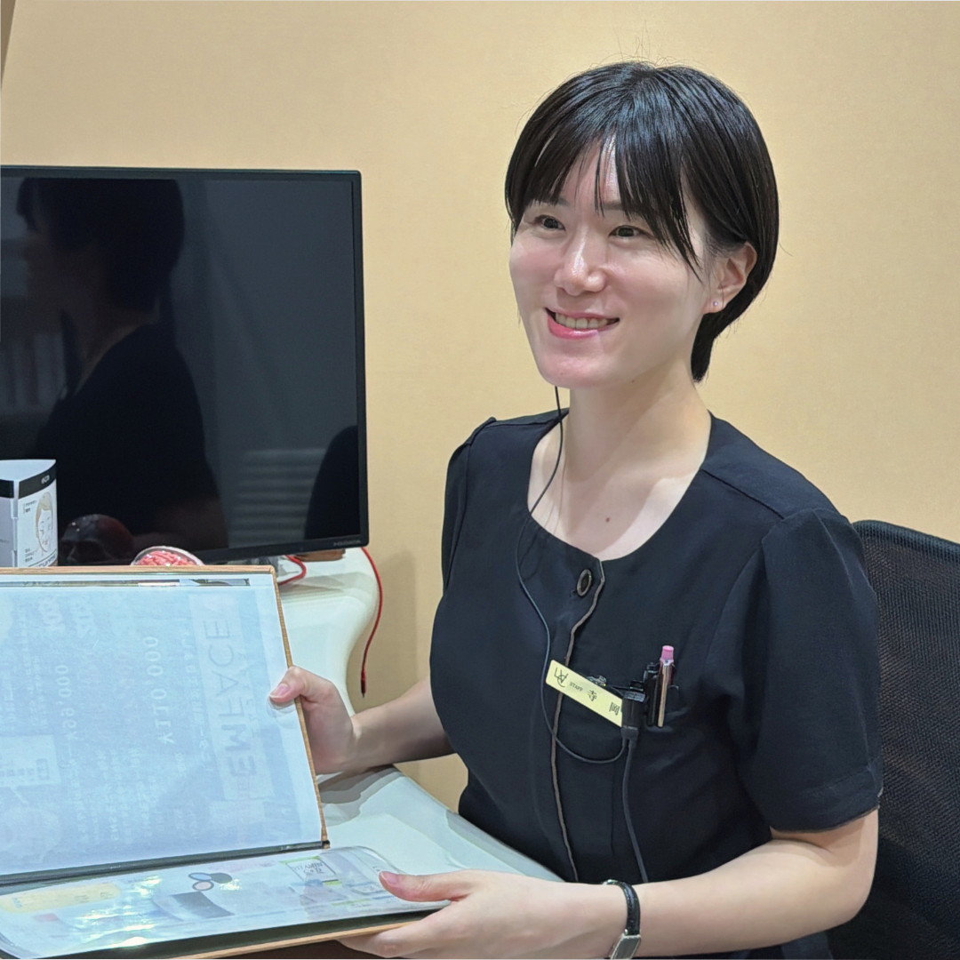資料を手に笑顔を見せるマネージャーTさん