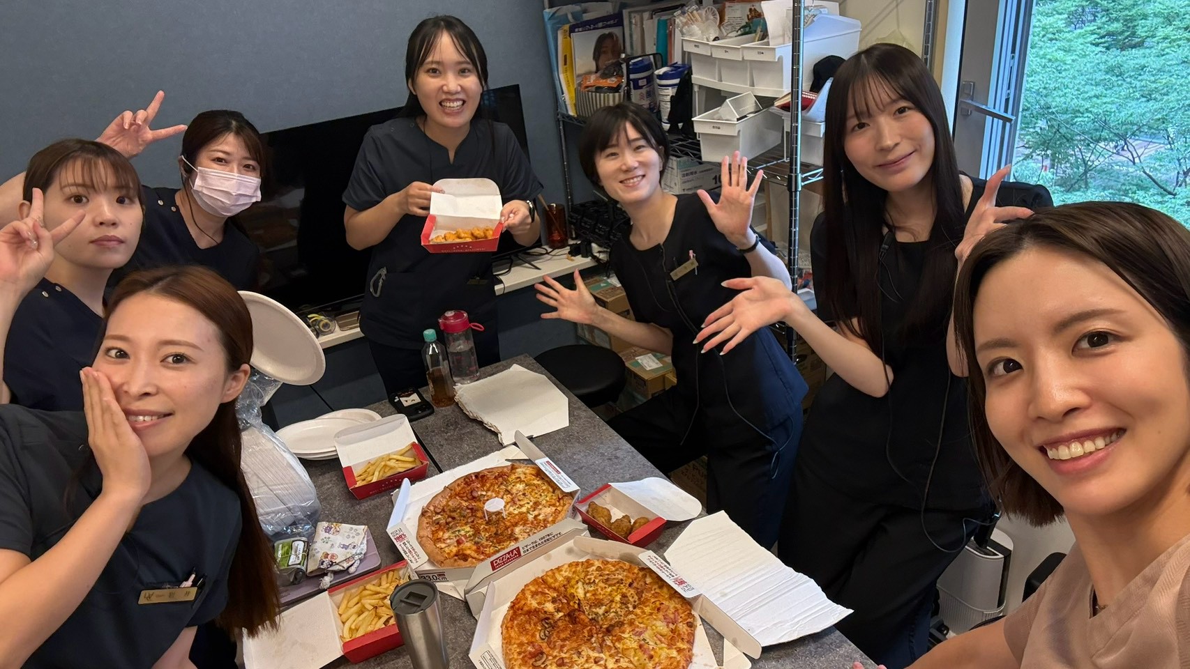 ピザを囲み、休憩時間を楽しむスタッフたち