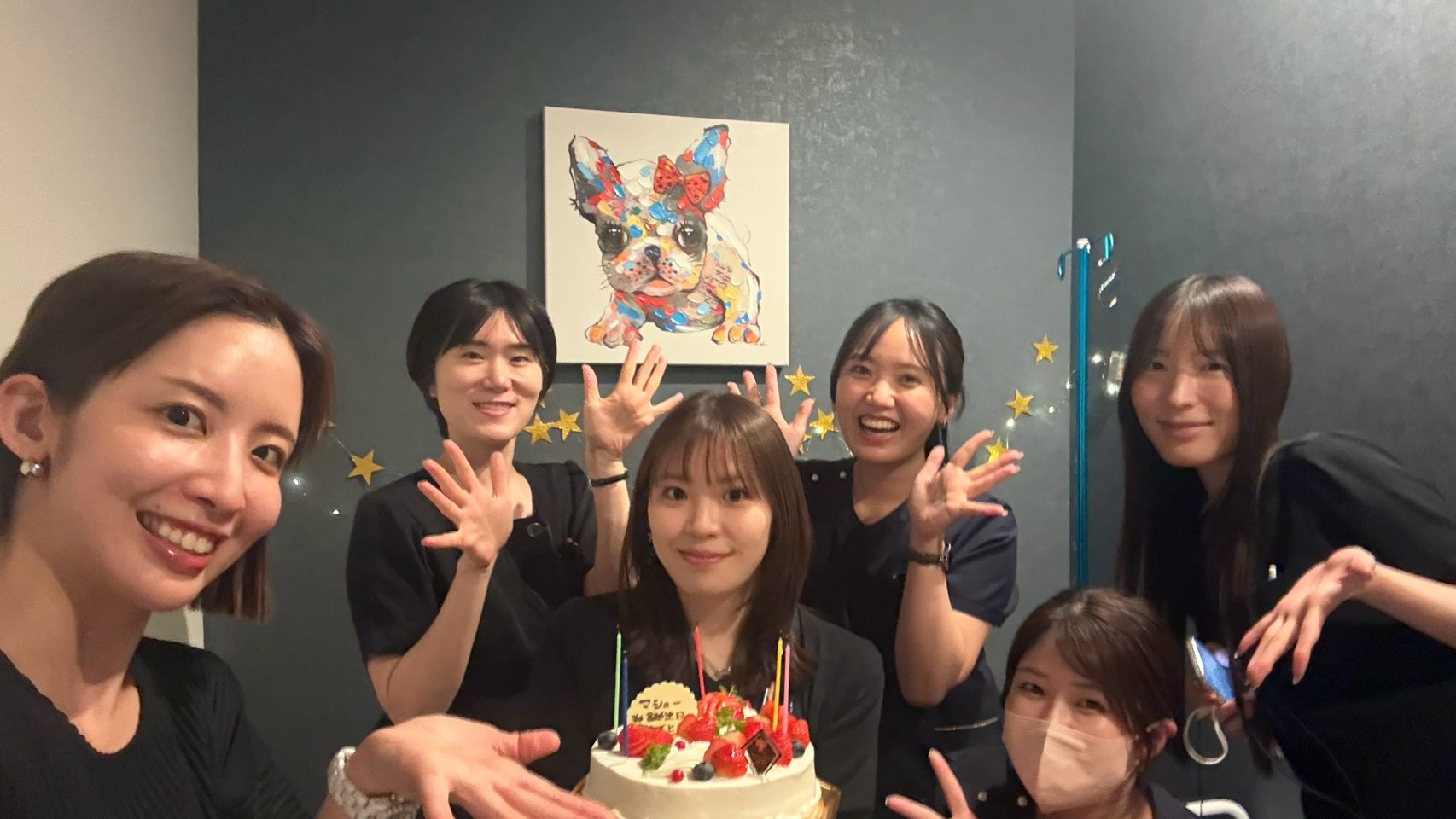 誕生日ケーキを囲んでお祝いするスタッフたち