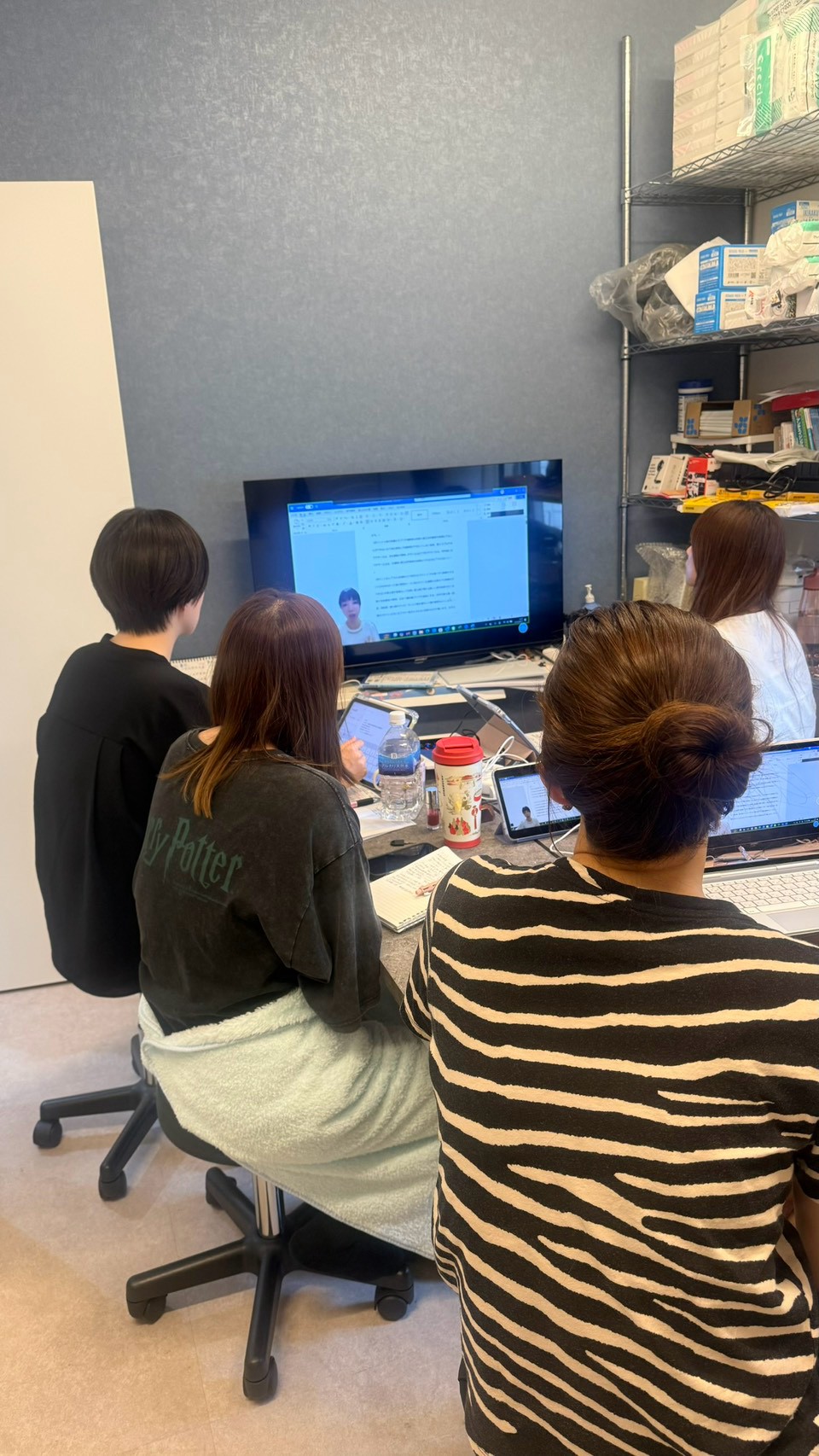モニターと資料を見ながら勉強会に参加するスタッフたち