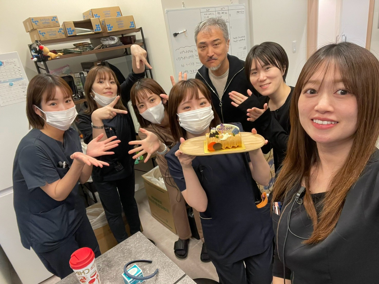 ケーキを手に集まり、笑顔で記念撮影するスタッフたち