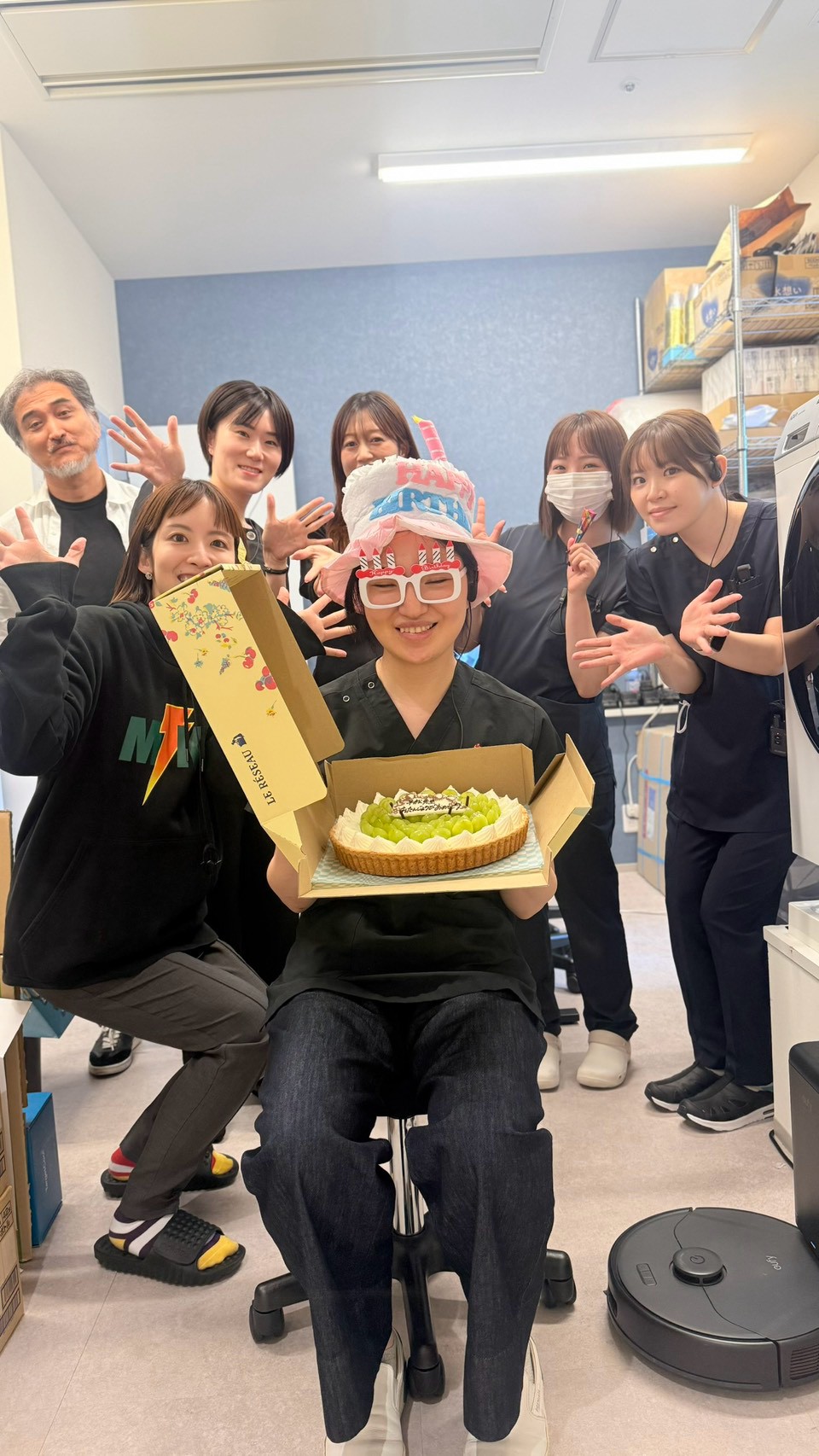 誕生日の帽子とケーキを用意して仲間をお祝いするスタッフたち