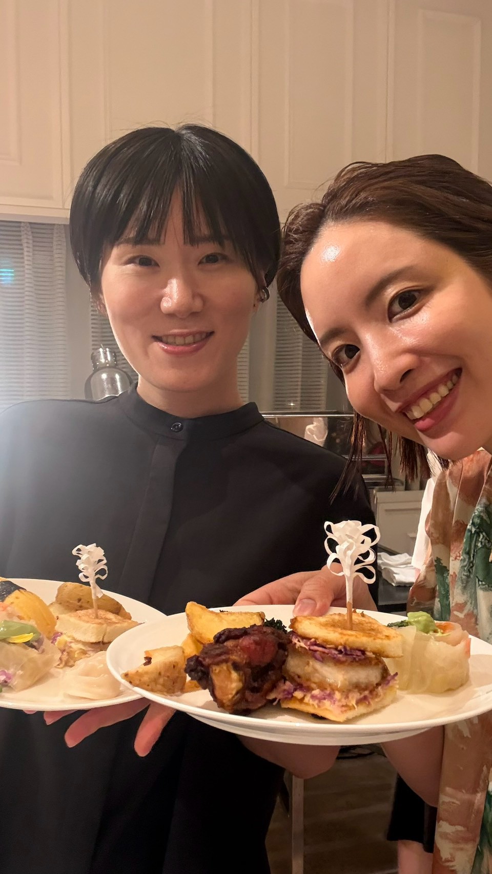 サンドイッチの皿を手に笑顔で並ぶ2人のスタッフ